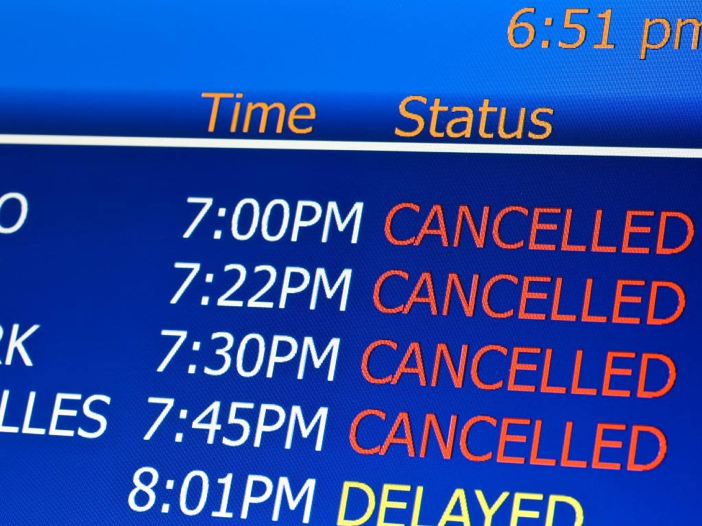 airport screen with list of canceled flights.