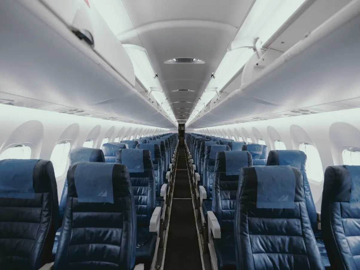 Looking down length of airplane from the interior with view of rows of seats. 